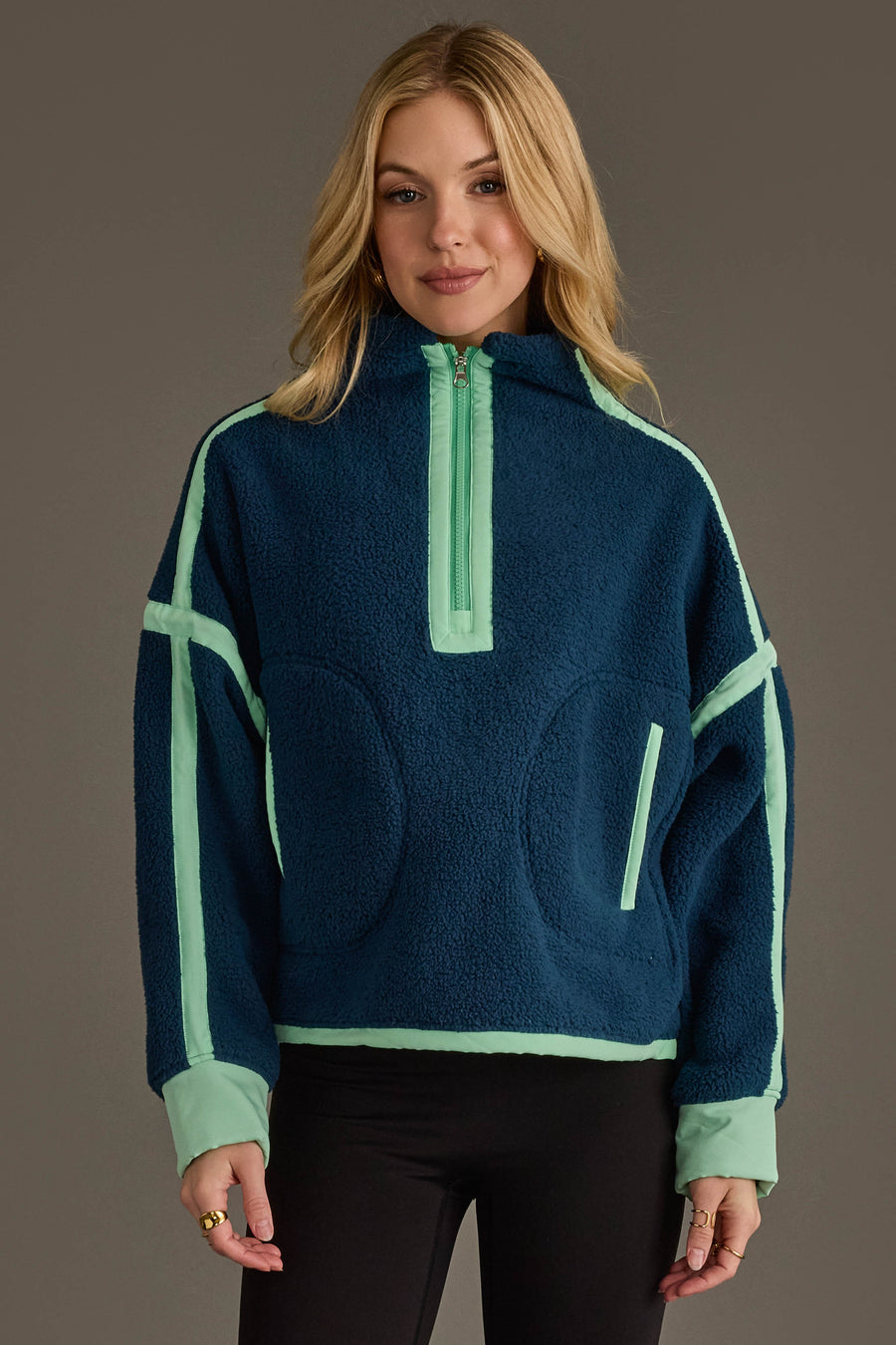 A woman with long blonde hair is wearing the Panache Apparel Collection Navy & Mint Half Zip Sherpa Fleece Sweatshirt, standing against a plain background and smiling softly at the camera.