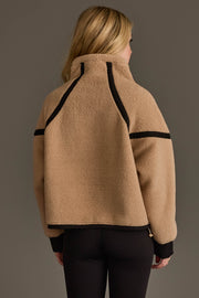 A person with long blonde hair, shown from the back against a plain background, is wearing the Panache Apparel Collection Tan & Black Half Zip Sherpa Fleece Sweatshirt paired with black leggings.