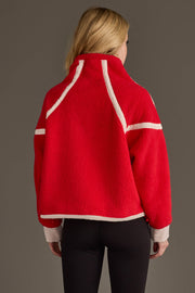 A woman with blonde hair is seen from behind against a plain background, wearing the Panache Apparel Collection’s Red & Beige Half Zip Sherpa Fleece Sweatshirt and black leggings.