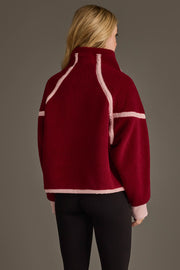 A person with long blonde hair, shown from the back against a plain background, is wearing the Panache Apparel Collection Burgundy & Light Pink Half Zip Sherpa Fleece Sweatshirt and black pants.