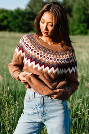 Outdoor close-up of a woman wearing Panache Apparel’s brown, gray, burgundy and white Fair Isle sweater with a patterned yoke.
