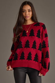 A person wears a Red & Black Tree Sweater, a red crewneck sweater featuring a repeating black pine tree pattern from the Panache Apparel Collection.