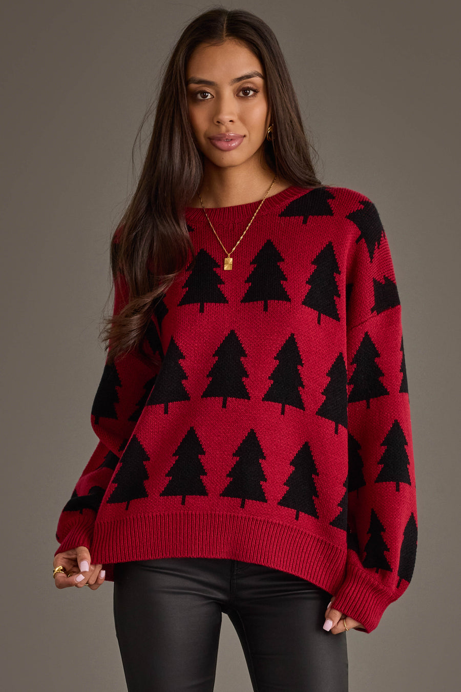 A person wears a Red & Black Tree Sweater, a red crewneck sweater featuring a repeating black pine tree pattern from the Panache Apparel Collection.