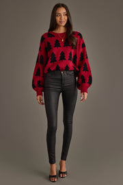 A woman wearing a Panache Apparel Collection Red & Black Tree Sweater with a black Christmas tree pattern and black skinny pants.