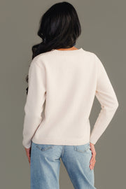 A person with long dark hair stands facing away against a plain gray background, wearing the Panache Apparel Collection Cream Soft Sweater and light blue jeans, with one hand resting on their hip.
