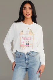 A white Merry Bar Cart Sweatshirt featuring a graphic of a holiday-decorated bar cart with the word MERRY hanging from it, worn with light-wash jeans.