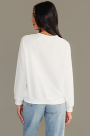 A person seen from the back wearing a Girl With Christmas Tree Sweatshirt in plain white and blue jeans.