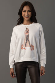 A woman smiles while wearing the Girl At Pumpkin Patch Sweatshirt by Panache Apparel Collection, featuring an illustration of a stylish woman, high heels, and pumpkins; she stands against a plain gray background.