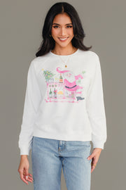 A woman wearing a white Panache Apparel Collection Santa Bar Cart Sweatshirt featuring a graphic of Santa Claus standing by a bar cart filled with drinks.