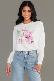 A woman wears a white long-sleeve Santa Bar Cart Sweatshirt from the Panache Apparel Collection, featuring a graphic of Santa Claus by a bar cart with drinks and a small Christmas tree.