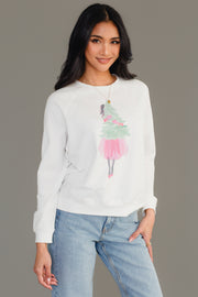 A person wearing a white long-sleeve Pink Girl Holding Tree Sweatshirt from the Panache Apparel Collection featuring a graphic of a girl in a pink skirt holding a Christmas tree.