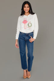 A woman wearing a white Panache Apparel Collection Christmas Girl & Dog Sweatshirt, paired with blue jeans and tan heels.