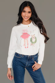 A woman wears a white Christmas Girl & Dog Sweatshirt featuring a watercolor-style illustration of a girl in a red skirt and a dog wearing a wreath.