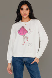 A woman wears a white long-sleeve Fancy Christmas Fa La La Sweatshirt featuring an illustration of a woman in a pink skirt, the text fa la la, and a string of Christmas lights.