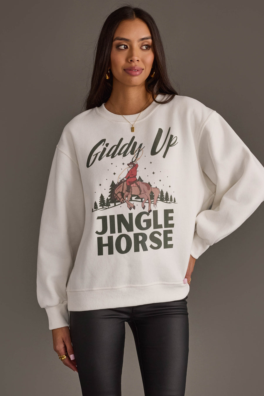 A person wears a Giddy Up Jingle Horse Sweatshirt featuring a graphic of a cowboy riding a horse with the text Giddy Up above and JINGLE HORSE below.