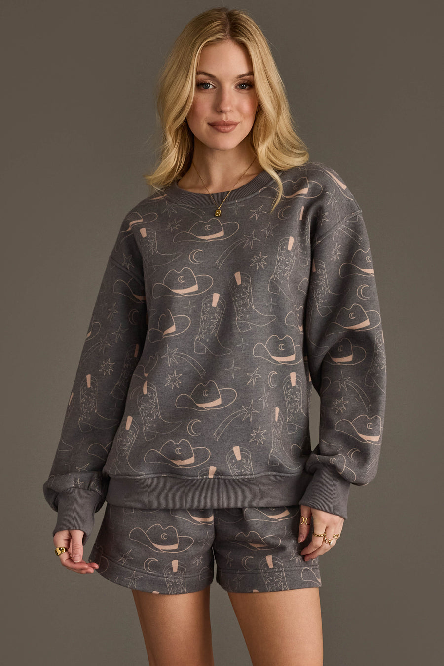 Woman wearing Panache Apparel’s charcoal western print sweatshirt and shorts set.