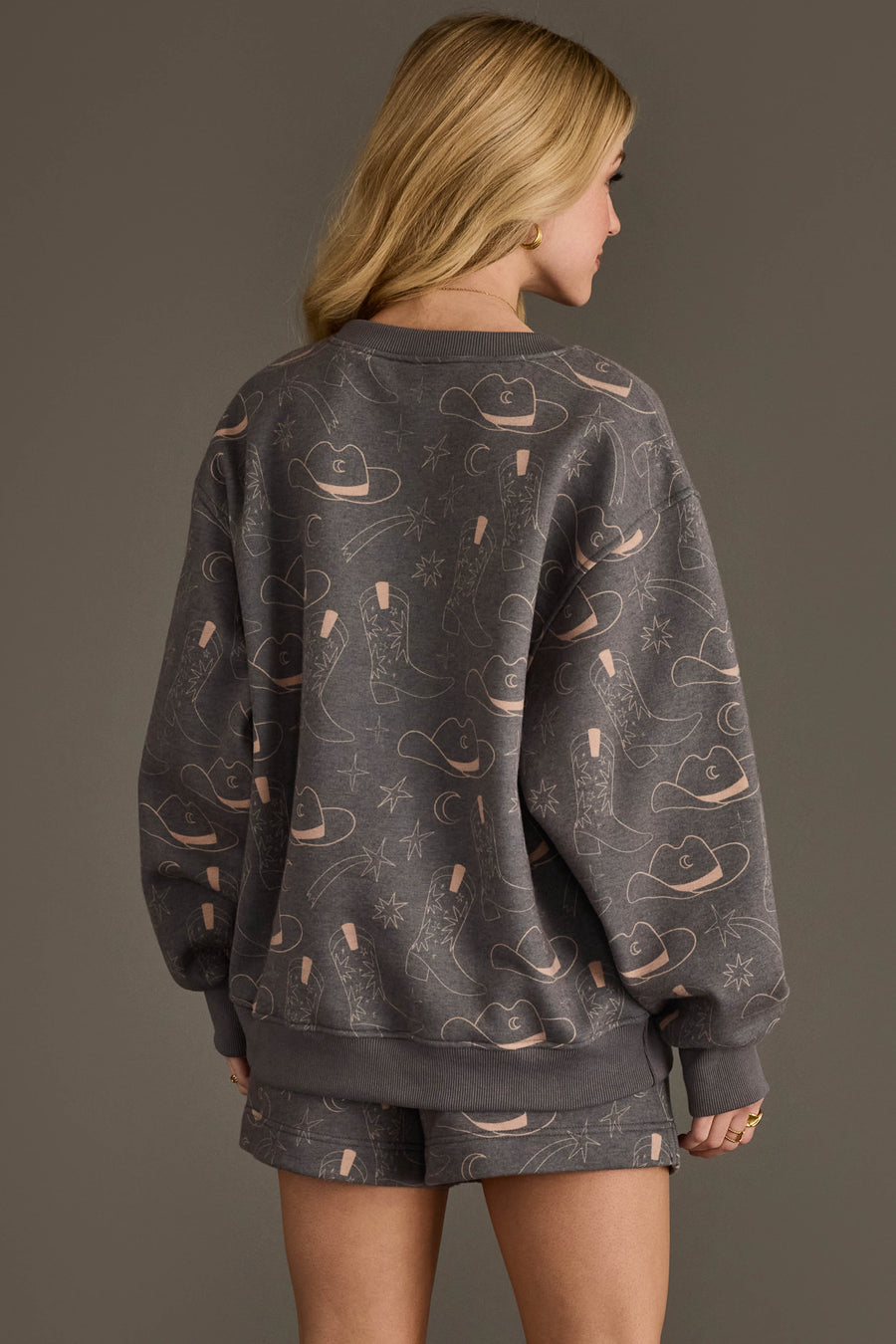 Back view of woman wearing Panache Apparel’s charcoal western print sweatshirt and shorts set.