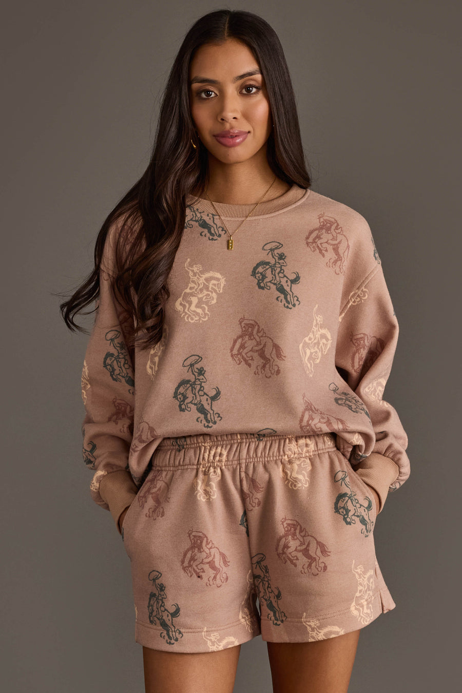 Woman wearing Panache Apparel’s dusty rose western print sweatshirt and lounge shorts set.