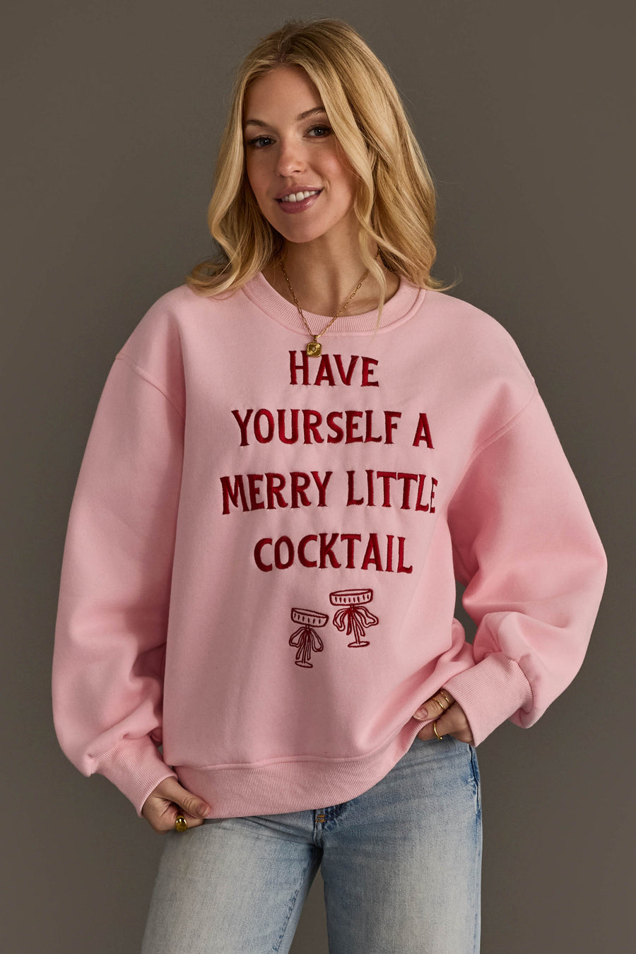 Panache Apparel Collection Pink Merry Little Cocktail Embroidered Sweatshirt in pink, featuring red embroidered text that reads Have yourself a merry little cocktail above two martini glasses.