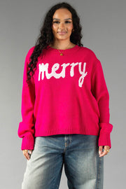A Pink & Light Pink Merry Sweater in a bright pink knit with a relaxed fit, featuring the word merry written in white script across the chest.