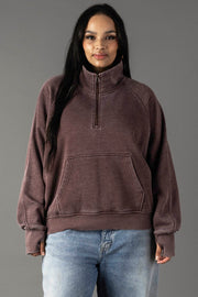 Plus-size woman wearing Panache Apparel’s reddish-brown quarter zip sweatshirt.