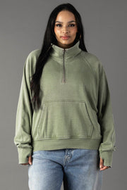 Plus-size woman wearing Panache Apparel’s sage quarter zip sweatshirt.