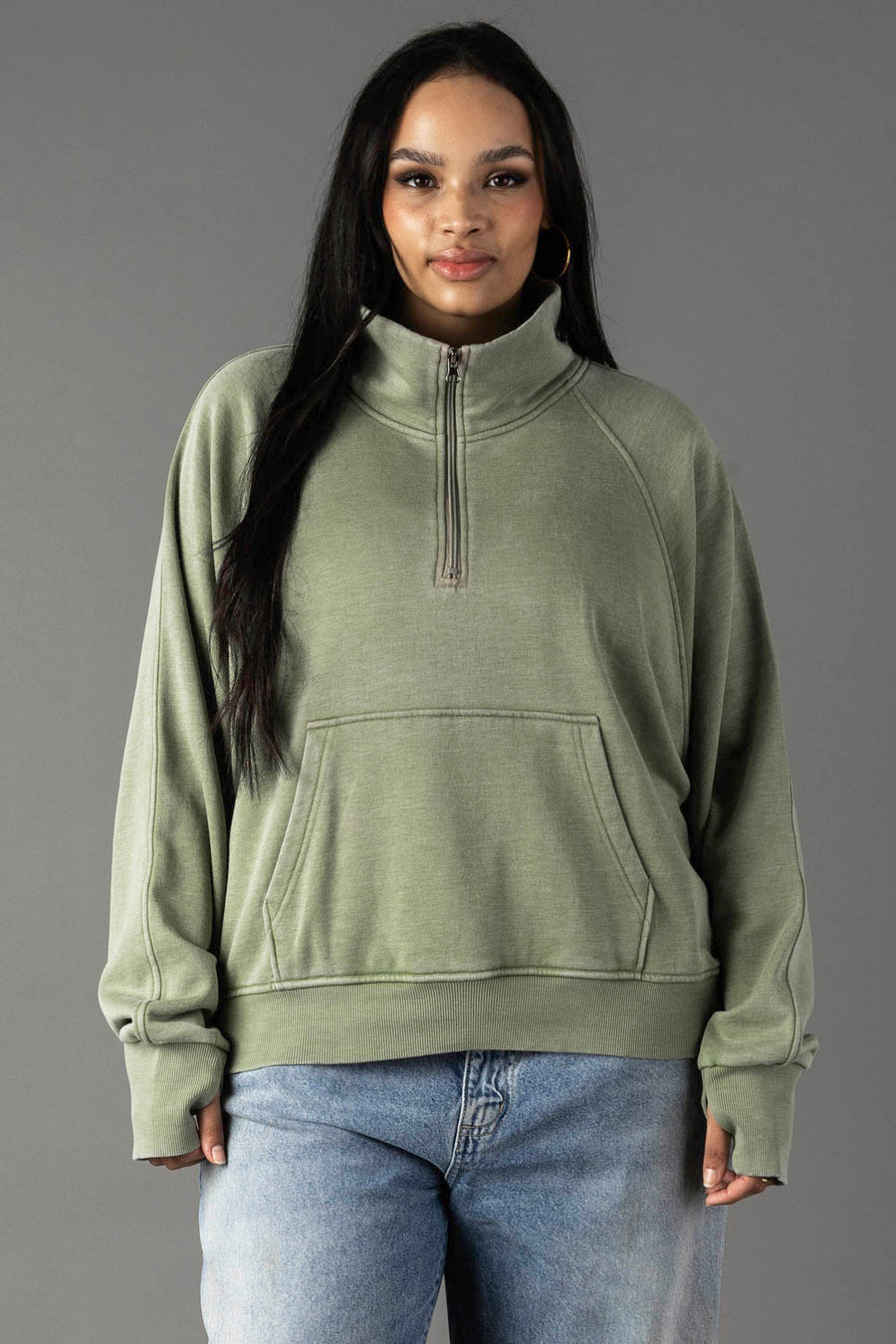 Plus-size woman wearing Panache Apparel’s sage quarter zip sweatshirt.
