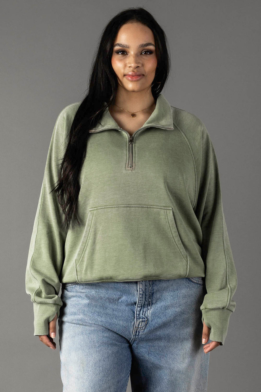 Plus-size woman wearing Panache Apparel’s sage quarter zip sweatshirt with an open collar.