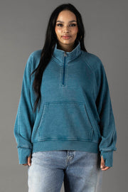 Plus-size woman wearing Panache Apparel’s dark teal quarter zip sweatshirt.