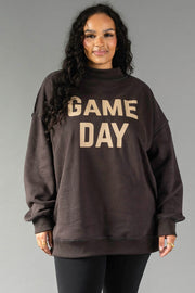 A woman with long curly hair wears the Panache Apparel Collection Dark Gray Game Day & Sunday Funday Reversible Sweatshirt and black leggings, standing against a plain gray background.