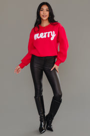 A person wearing a cozy red and white Panache Apparel Collection Red & White Merry Sweatshirt, paired with black pants and black knee-high boots.