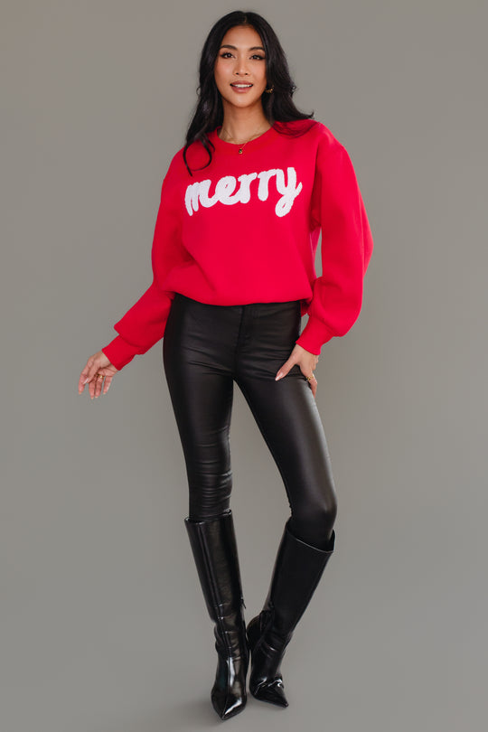 A person wearing a cozy red and white Panache Apparel Collection Red & White Merry Sweatshirt, paired with black pants and black knee-high boots.