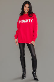 A woman wears a Red Nice & Naughty Reversible Sweatshirt with the word NAUGHTY printed in white across the chest, paired with black leggings and knee-high boots.