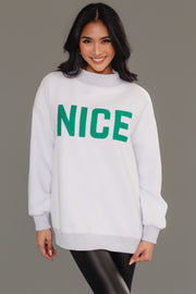 A person wearing a cozy, light gray, reversible Gray Nice & Naughty Reversible Sweatshirt from Panache Apparel Collection with the word NICE in green lettering on the chest.