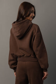 Back view of Panache Apparel’s brown hoodie showing the hood and ribbed waistband detail.