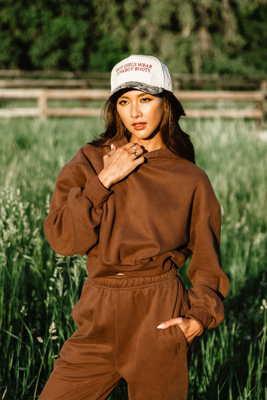 Woman wearing Panache Apparel’s brown hoodie and matching sweatpants in an outdoor lifestyle setting.