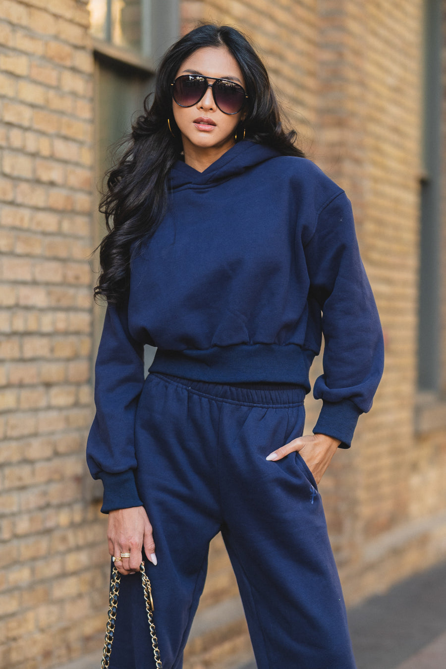 A person wearing a Dark Navy Panache Cropped Hooded Sweatshirt and matching sweatpants.