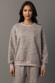 A woman wears the Panache Apparel Collection Cream & Brown Leopard Sweatshirt paired with matching pants, standing against a plain gray background and facing forward with a neutral expression.