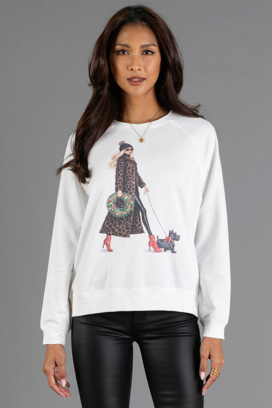 Panache Apparel Collection Girl Walking Dog with Christmas Wreath Sweatshirt featuring a white design of a woman in a leopard-print coat and red heels walking a small dog while holding a Christmas wreath.