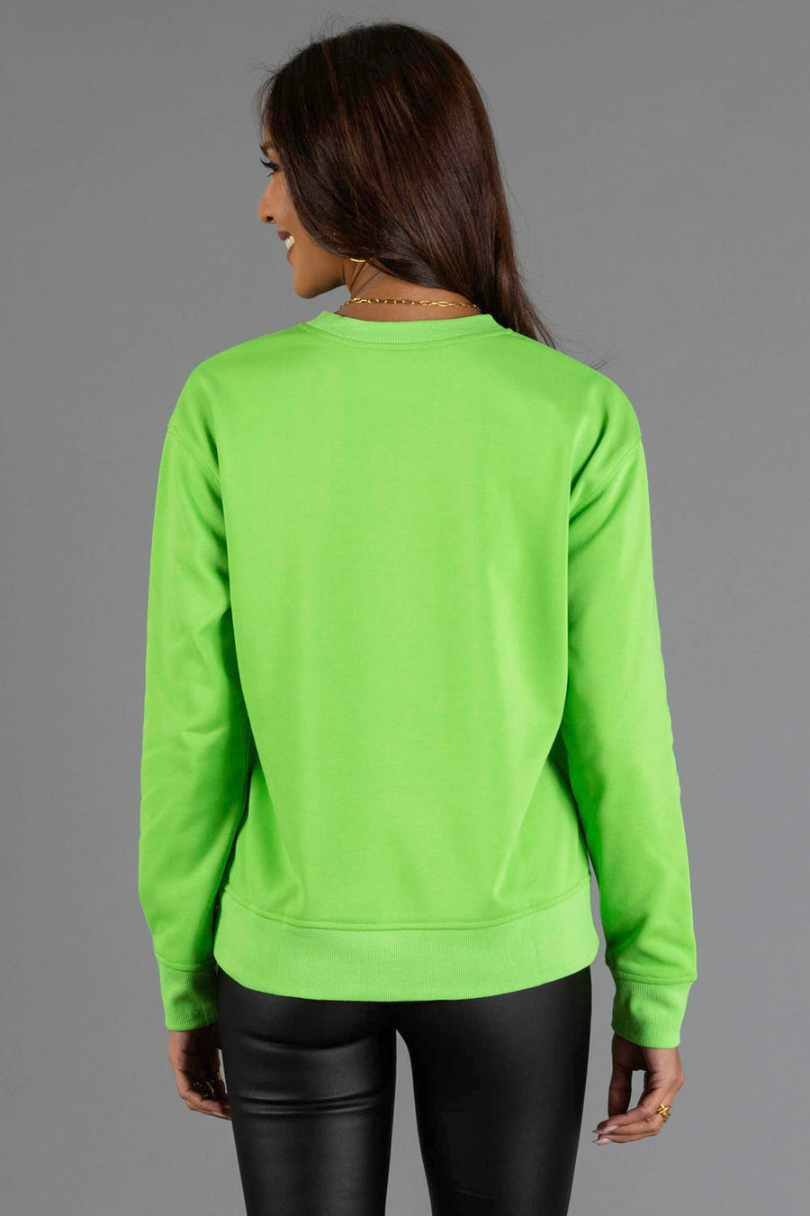 Back view of a person wearing a bright green, lightweight Bright Green Merry Sweatshirt.