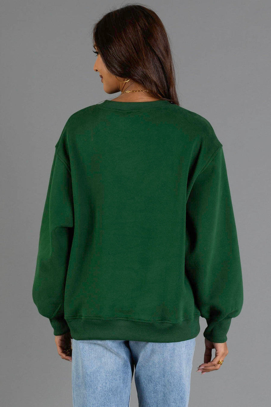 A person wearing the Panache Apparel Collection’s Green & Tan Cabin Fever Sweatshirt and light blue jeans is standing with their back to the camera against a plain gray background.