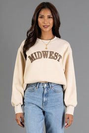 A person wearing the Tan & Dark Brown Midwest Sweatshirt from Panache Apparel Collection and light blue jeans stands against a plain gray background, smiling at the camera.