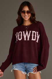 A woman wearing sunglasses and a Maroon Howdy Lightweight Sweater from Panache Apparel Collection, paired with denim shorts, is smiling and posing against a plain background.