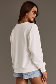 A woman wearing sunglasses, ripped denim shorts, and the Panache Apparel Collection Western Sign Sweatshirt is standing with her back to the camera against a plain, neutral background.