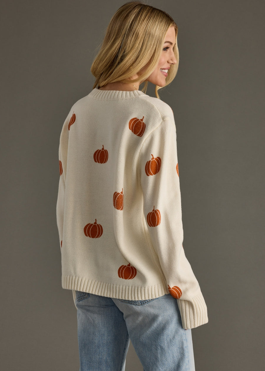 Back view of Panache Apparel’s ivory knit pumpkin sweater featuring an allover orange design.