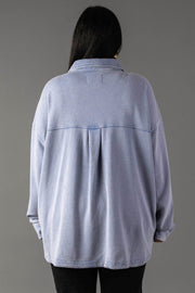 A person with long dark hair, shown from the back against a plain gray background, wears Panache Apparel Collection's Light Blue Washed Soft Button Up styled with black pants.
