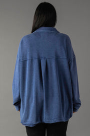 A person with long dark hair is seen from behind, wearing the Panache Apparel Collection Dark Blue Washed Soft Button Up and black pants against a plain gray background.