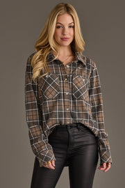 A person with long blonde hair wears the Gray, Tan & White Plaid Button Up from Panache Apparel Collection and black leather pants, standing against a plain gray background.