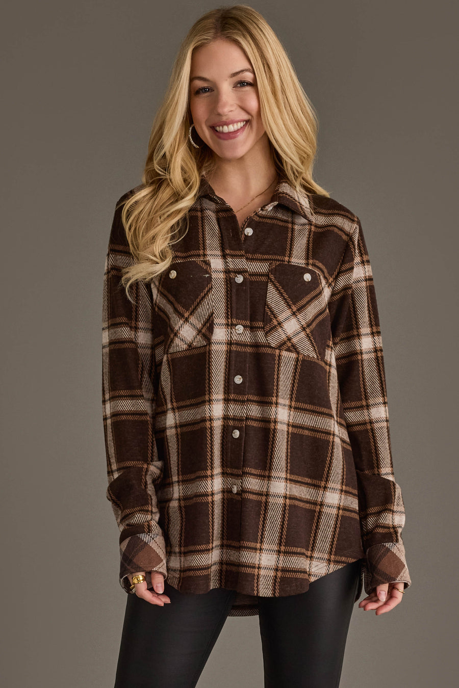 A smiling woman with long blonde hair wears the Panache Apparel Collection Dark Brown, Cream & Black Plaid Button Up and black pants, standing against a plain gray background.