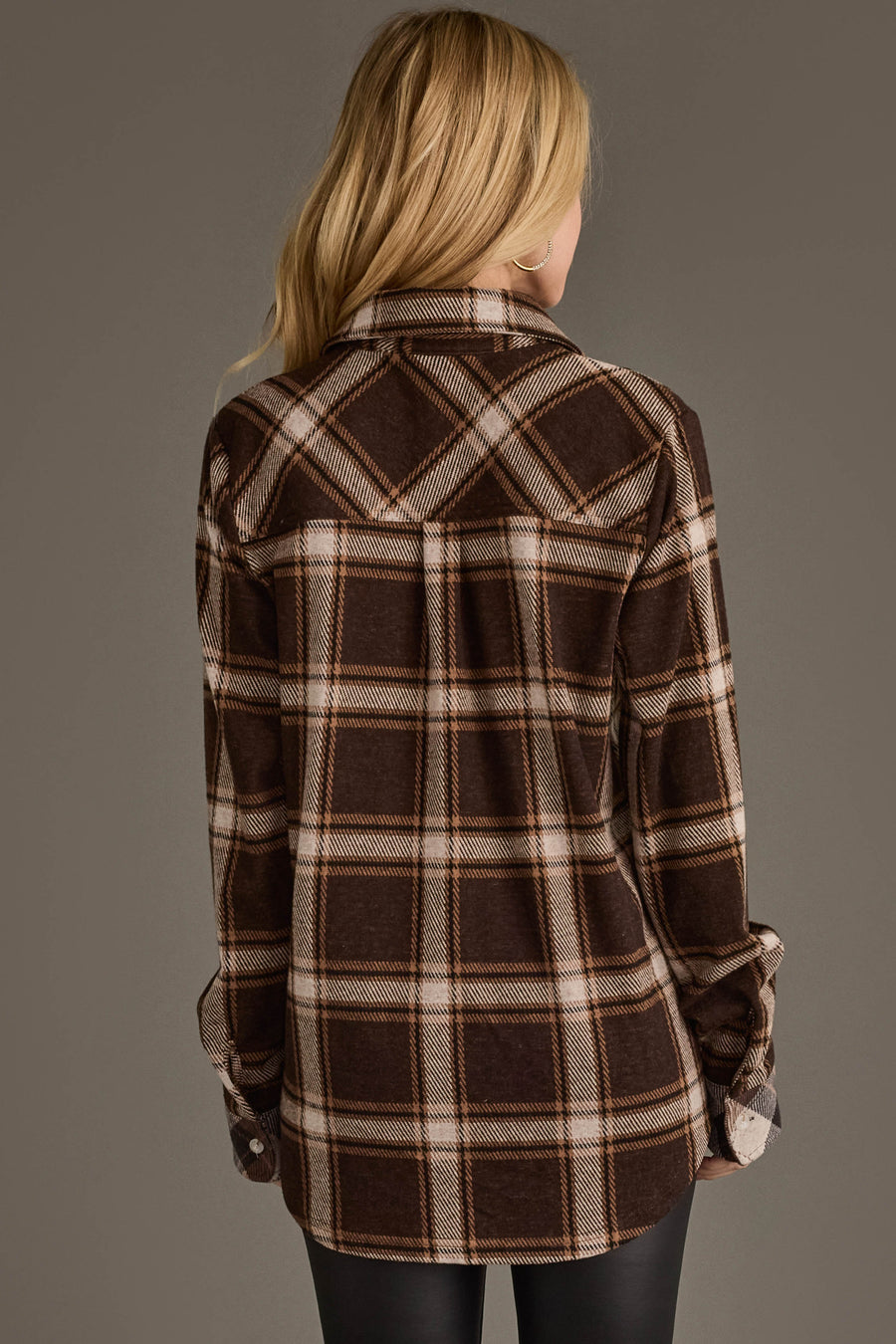 A person with long blonde hair is shown from the back, wearing the Panache Apparel Collection’s Dark Brown, Cream & Black Plaid Button Up with rolled sleeves and black pants against a plain background.